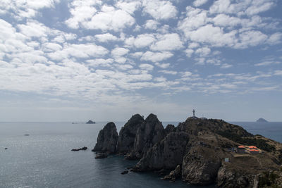 Scenic view of cliff and sea against sky