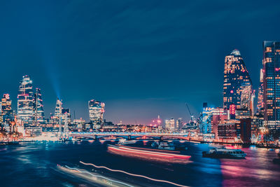 Illuminated cityscape against sky at night