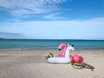 Colorful beach floaties against clear blue sky