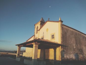 Low angle view of old building against clear blue sky