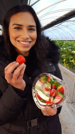 Portrait of a smiling young woman holding ice cream