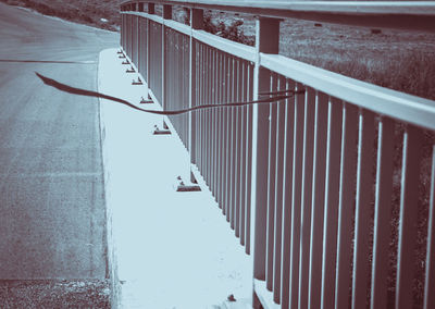 Road by railing during winter
