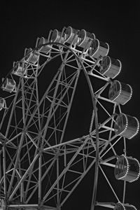 Low angle view of ferris wheel against black background