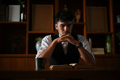 Businessman with hands intertwined sitting at desk