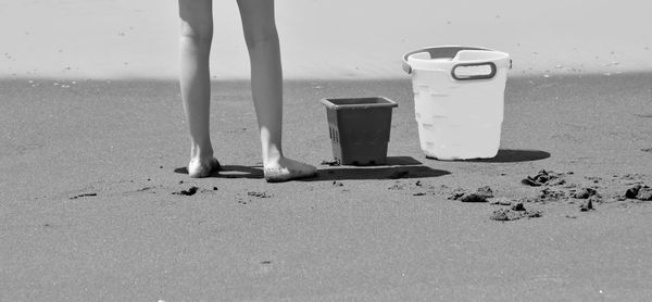 Low section of person standing at beach