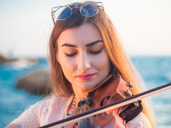 Close-up of young woman against sea