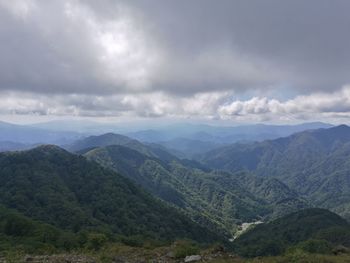 Scenic view of valley and mountains against sky