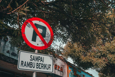 Low angle view of road sign against trees