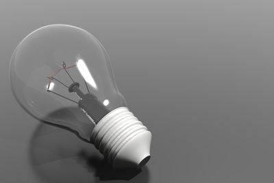 Close-up of light bulb over gray background