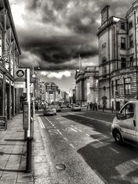 Buildings in city against cloudy sky