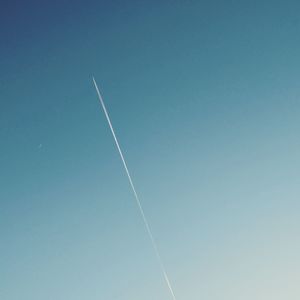 Low angle view of vapor trail against clear blue sky