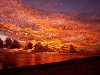 Scenic view of sea against dramatic sky during sunset