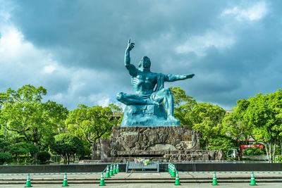 Peace statue in nagasaki against cloudy sky