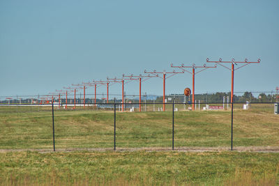 Fence on field against clear sky