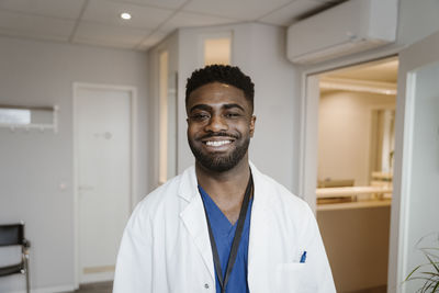 Portrait of smiling young male doctor wearing lab coat at hospital