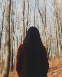 Rear view of woman standing in forest