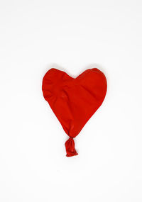 Close-up of red heart shape over white background