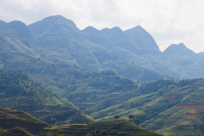 Scenic view of valley and mountains against sky