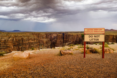 Information sign on landscape against sky