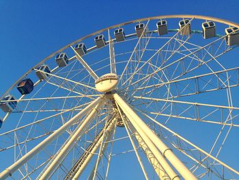 Low angle view of ferris wheel against blue sky