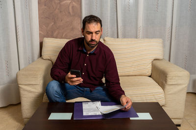 Young man sitting on sofa at home