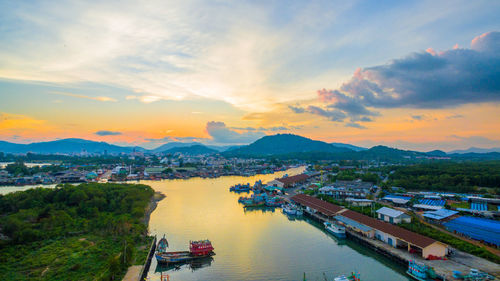 High angle view of river amidst cityscape against sky during sunset