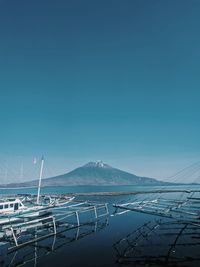 Sailboats in sea against clear blue sky