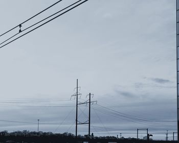 Low angle view of electricity pylon against sky