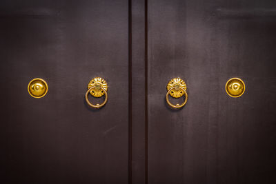 Close-up of closed wooden doors with golden handles