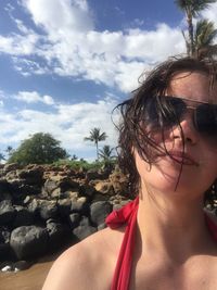 Midsection of woman at beach against sky
