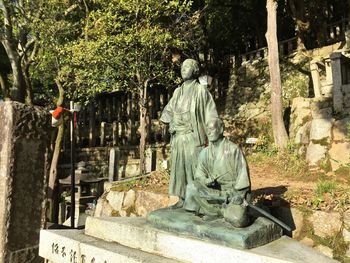 Statue against trees and plants