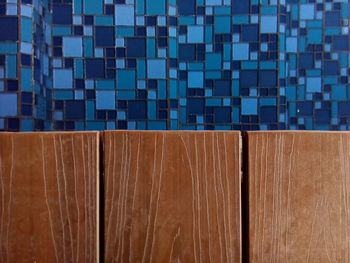 Close-up of wooden door against tiled wall in bathroom