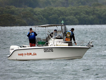 People in boat sailing on sea