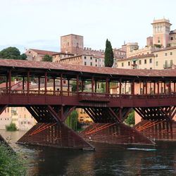 Bridge over river in city against clear sky