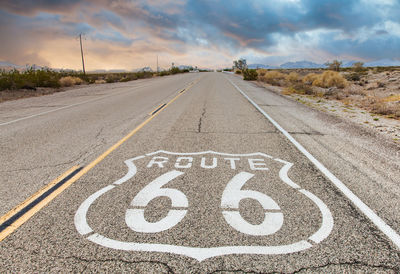 View of road sign against cloudy sky