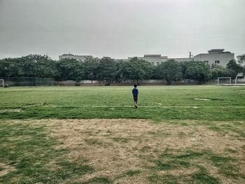 Man playing on field against sky