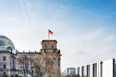 Low angle view of german flag on the reichstag against sky