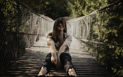 Rear view of women standing on footbridge