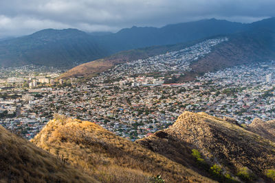 Aerial view of townscape and mountains against sky