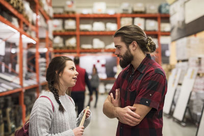 Couple discussing while standing in hardware store