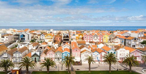 High angle view of townscape by sea against sky