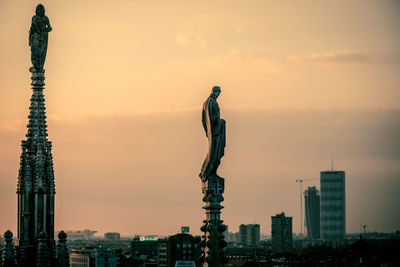 Statue of city against sky during sunset