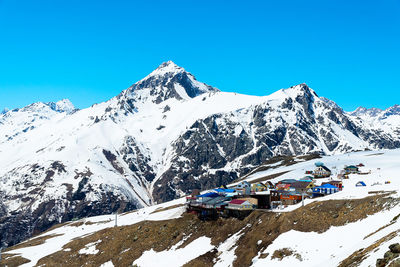 Scenic view of snowcapped mountains against clear blue sky