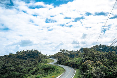 Scenic view of road by trees against sky