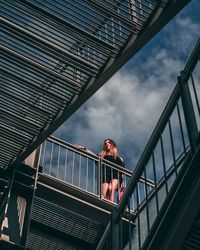 Low angle view of man standing on bridge against sky