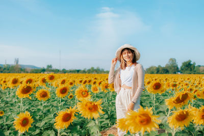 Woman standing on sunflower field