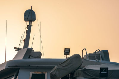 Cranes against sky at sunset