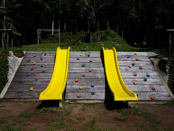 Yellow playground against trees in park