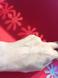 Low section of woman with hand on red background