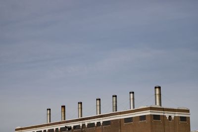 Low angle view of factory against sky